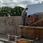 ALUMNES D'OBRA CONSTRUEIXEN UN MUR AMB BLOCS DE CIMENT COM A PART DE LA SEUA FORMACIÓ PRÀCTICA